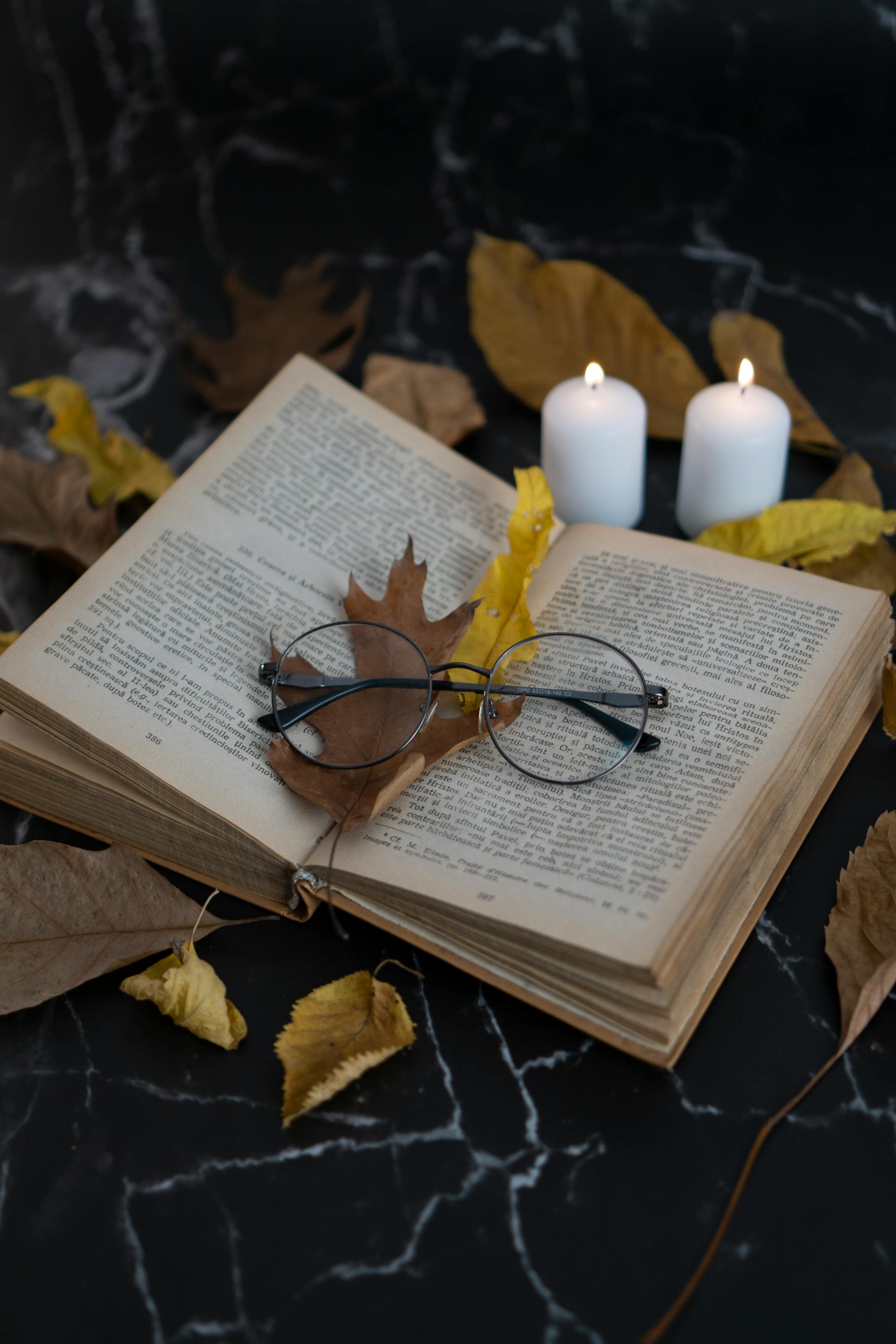 A worn sefer and reading glasses resting on an open page &mdash; the quiet, familiar setting of a beis medrash.